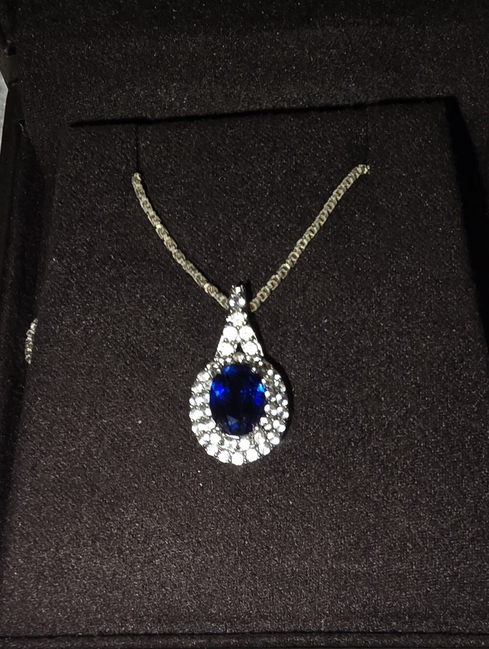 Stunning teardrop halo pendant features a deep royal blue Sapphire Sterling